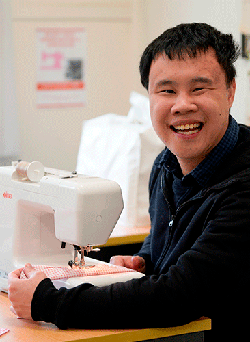 NDIS participant, Johnny, using sewing machine