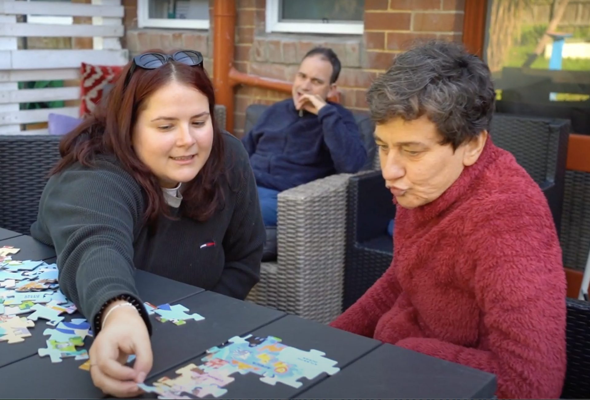 Client and support worker solving a puzzle
